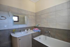 ein Badezimmer mit einem Waschbecken und einer Badewanne in der Unterkunft Lidromi Home (Blue) in Alonnisos Altstadt