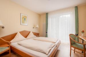 een slaapkamer met een bed, een bureau en een raam bij Zum Waldhorn in Peterstal +22 foto's