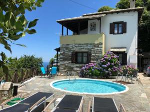 a villa with a swimming pool in front of a house at TESSERA Tsagarada Villa with a Private Pool in Tsagarada