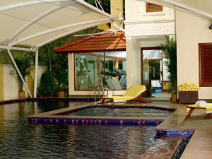 
a swimming pool with a large umbrella on top of it at The Paul Bangalore in Bangalore
