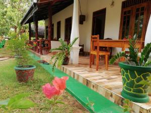 a porch of a house with plants and a piano at Sigiri Binara Villa in Sigiriya