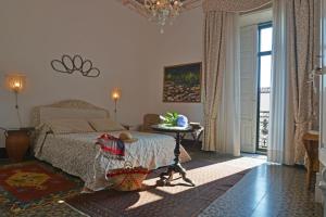 Schlafzimmer mit einem Bett und einem Tisch in der Unterkunft B&B di Charme Camelie in Riposto
