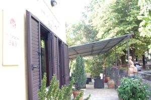 Markierung über einer Terrasse mit Pflanzen und einem Gebäude in der Unterkunft Mariani Bed&Breakfast in Castellina in Chianti
