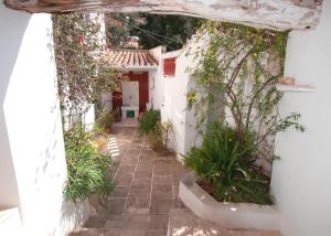 an alley with a white building with plants at Rallou House Hydra in Hydra