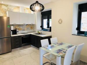 a kitchen with a white table and a refrigerator at Villa Stephanie in Hanioti