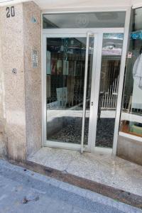 カディスにあるApartamento a un pasito del mercadoの窓の反射窓が付いた建物の開口ドア