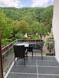a patio with two chairs and a table on a balcony at Haus Osterlämmchen in Ediger-Eller