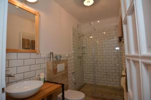 a bathroom with a sink and a glass shower at Mini Loft Apartman in Eger