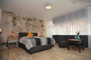ein Schlafzimmer mit einem Bett und einem Stuhl in der Unterkunft Mini Loft Apartman in Eger
