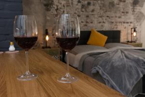 zwei Gläser Wein auf einem Holztisch in der Unterkunft Mini Loft Apartman in Eger