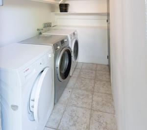 eine Waschküche mit einer Waschmaschine und einem Waschbecken in der Unterkunft Résidence Carpe Diem in Marseille