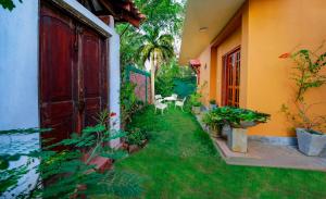 a garden outside a house with a red door at Kamal Villa in Ahungalla