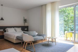 a bedroom with a bed and a chair and a table at Furnas Lake Forest Living in Furnas