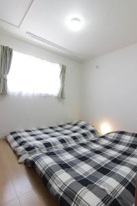 Un pat sau paturi într-o cameră la Guesthouse Tokushima