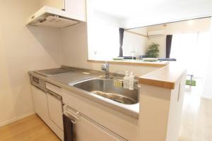 a kitchen with a sink and a counter at Guesthouse Tokushima in Tokushima