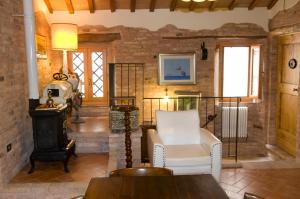 a living room with a white chair and a stove at B&B La Cappellania in Montegiorgio