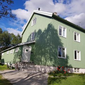 a green building with a bicycle parked in front of it at Solheim Pensjonat in Røros