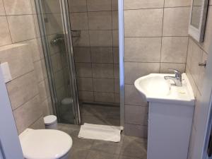 a bathroom with a shower and a toilet and a sink at Apartamenty PRIMA in Rewal +65 photos