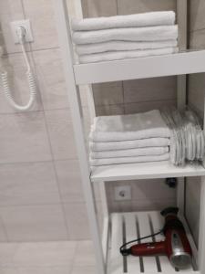 een wit handdoekenrek met handdoeken in de badkamer bij Elegant apartment close to the Old Town in Vilnius