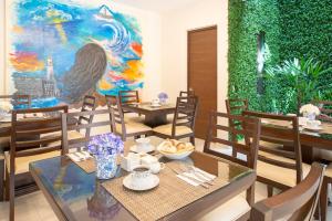 una sala da pranzo con tavoli, sedie e un dipinto di Hotel Posada XR a Córdoba
