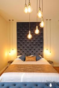 a bedroom with a large bed with lights on it at Three Pearls Deluxe Rooms & Studios in Zadar