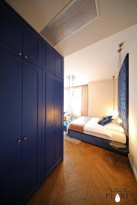 een slaapkamer met een bed en een blauwe kast bij Three Pearls Deluxe Rooms & Studios in Zadar