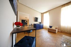 a living room with a table and a room with a couch at Three Pearls Deluxe Rooms & Studios in Zadar