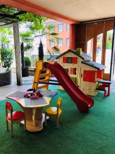 um parque infantil com um escorrega, uma mesa e cadeiras em Hotel Römer em Günzburg