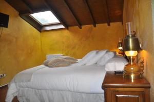 1 dormitorio con cama blanca y ventana en Hotel Peñalba, en La Riera