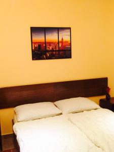 a bedroom with two white beds and a picture on the wall at Apartman Lovor in Medulin +4 photos