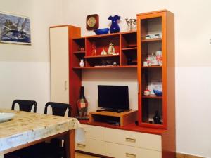 a living room with a entertainment center with a television at Apartman Lovor with free, secure parking in Medulin