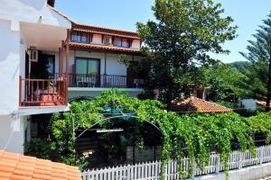 a house with a white fence and vines at Chrissomalli Sofia Studios in Skiathos