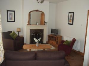 a living room with a couch and a table at Aird Cottage in Aird