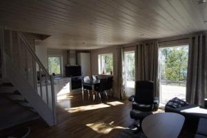 a living room with a staircase and a table and chairs at Karistua in Hansnes