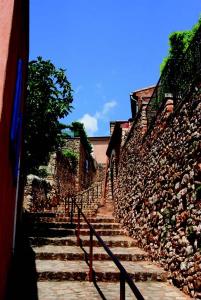 un escalier en pierre à côté d'un mur en pierre dans l'établissement La goutte d'or, à Roussillon