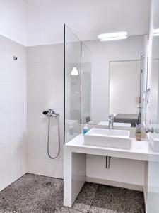 a white bathroom with a sink and a shower at Brand new budget apartment next to Iaso and Oaka in Athens
