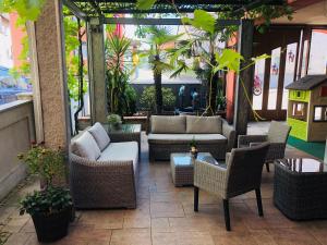 a patio with couches and chairs and a table at Hotel Römer by Fairway Hotels in Günzburg