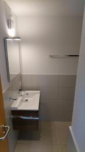 a white bathroom with a sink and a mirror at Ferienwohnung Duttental in Tuttlingen