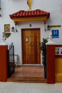 einer Eingangstür eines Hauses mit einer Holztür in der Unterkunft Hostal Playa Hidalgo in Rota