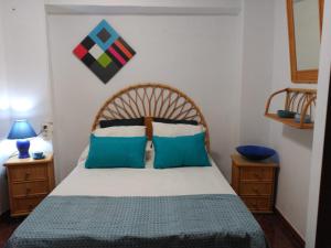- une chambre avec un grand lit et des oreillers bleus dans l'établissement Ca la Motrila, à Buñol