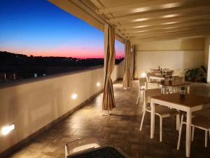 un ristorante con tavoli e sedie su un balcone di B&B Vivere San Vito Lo Capo a San Vito lo Capo