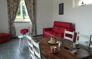 a living room with a table and a red couch at Le Gite de l'Etrier in Canchy