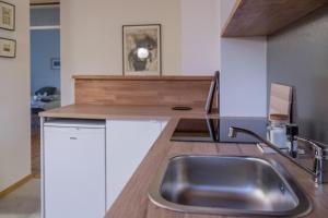 a kitchen with a sink and a wooden counter top at HOMe apartments & Yoga studio in Bled-Rečica +58 photos