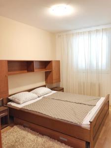 sypialnia z łóżkiem z drewnianym zagłówkiem w obiekcie Villa Masha w mieście Omišalj