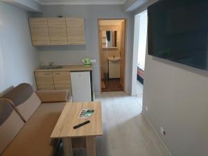 a living room with a table and a kitchen at Noclegi nad Soliną in Solina