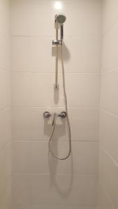 y baño de azulejos blancos con ducha. en Luxury Suite Lilas, en Dijon