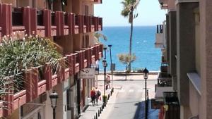 people walking down a street with the ocean in the background at Apartamento Cervantes in Fuengirola