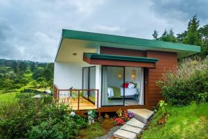 a small house with a bedroom and a balcony at Quinta Esencia in Alajuela