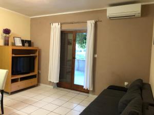 a living room with a couch and a television at Apartment Bura in Šibenik