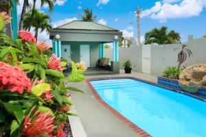a house with a swimming pool and flowers at Parador El Buen Cafe in Hatillo